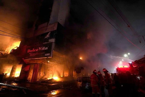 Firefighters struggle to contain a fire at a multi-story commercial building in Karachi, Pakistan, Wednesday, Dec. 6, 2023. (Photo | AP)