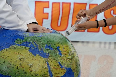 Activists pretend to resuscitate the Earth during a demonstration at the COP28 UN Climate Summit, Wednesday, Dec. 6, 2023, in Dubai, United Arab Emirates. (AP Photo)