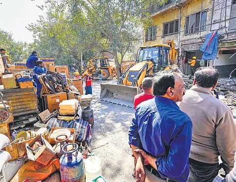 People look at the demolition of alleged illegal structure during an  anti-encroachment drive by the DDA at Mehrauli in New Delhi. (File photo | PTI)