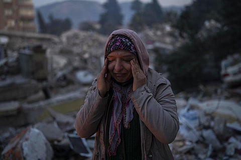 Nearly two weeks after a massive earthquake leveled tens of thousands of buildings and displaced millions of people in Turkey and Syria, many are still struggling to fulfill their basic needs and some are bedding down in tents, factories, train cars and greenhouses. Aysegul Aytulun cries as she talks about five family members who are thought to have died during the earthquake on Monday in Antakya, southeastern Turkey, on Feb. 12, 2023. The surviving relatives have been camped out in front of the damaged building, hoping that someone can recover the bodies. (Photo | AP)