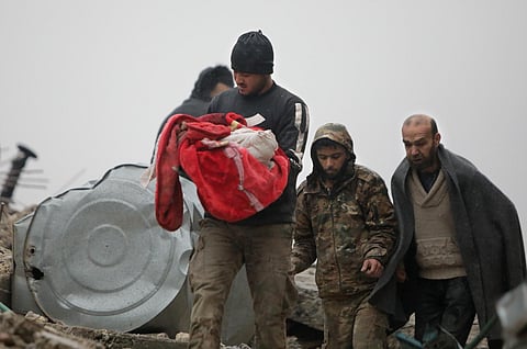 A Syrian man carries the body of an infant who was killed in an earthquake in the town of Jandaris, in the rebel-held part of Aleppo province, on Feb 6, 2023. (Photo | AFP)