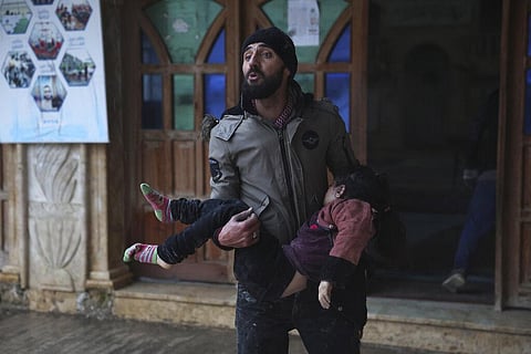 A Syrian man carries a dead young girl, in Azmarin town, in Idlib province north Syria, Monday, Feb. 6, 2023. (AFP)