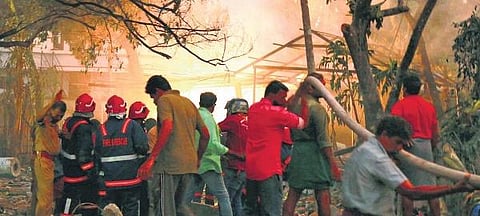 Rescue workers and residents take cover as minor blasts continue at the fireworks manufacturing unit at Muttinakam in Varapuzha, Kochi, on Tuesday | T P Sooraj 