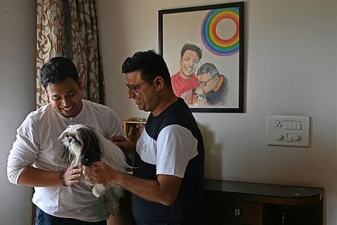 Abhay Dang (R) and Supriyo Chakraborty, who have petitioned India’s Supreme Court to legalise same-sex marriages, pose for a picture with their dog at their home in Hyderabad. (Photo | AFP)