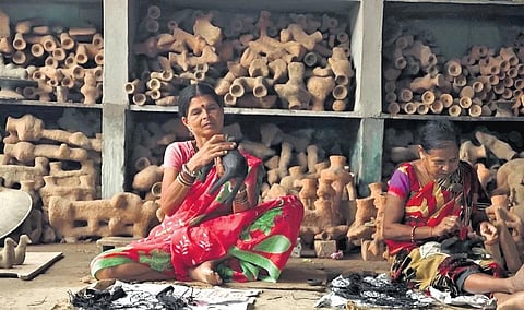Community members crafting Dhokra pieces.