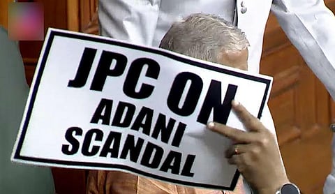 An Opposition lawmaker holds a placard during a protest in the Lok Sabha demanding a Joint Parliamentary Committee probe into the Adani Group, March.22, 2023. (Photo | ANI)