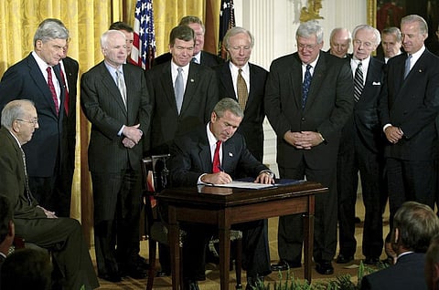 Ex-US President George W Bush signs a resolution authorizing the use of force against Iraq, on Oct. 16, 2002. (File Photo | AP)