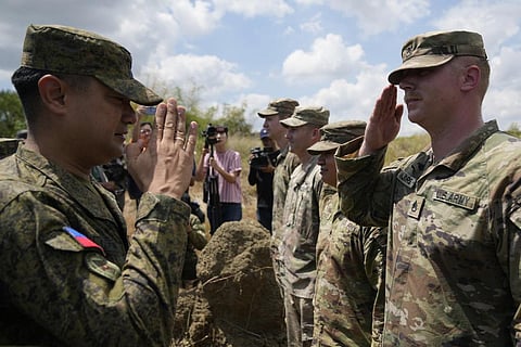 Philippine Army Artillery Regiment Commander Anthony Coronel (L) returns a salute from a US soldier during a joint military drill in northern Philippines, March 31, 2023. (Photo | AP)