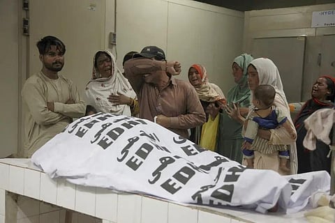 A family mourns next to the body of their family member, who died in the stampede, at a morgue, in Karachi, Pakistan, Friday, March 31, 2023. (Photo | AP)