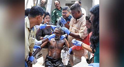 Social worker Theruvoram Murugan and Thampanoor police cleaning a vagabond in Thiruvananthapuram city.(Photo | Vincent Pulickal)
