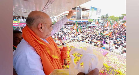 Union Home Minister Amit Shah during a roadshow ahead of Karnataka Assembly elections, at Gundlupet in Chamarajanagar district. (Photo | PTI)