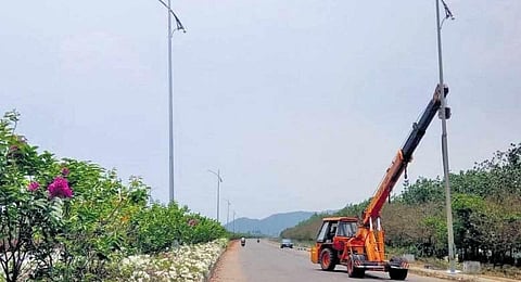 Workers erecting poles to install electric street lights in Amaravati. (Photo | Express)