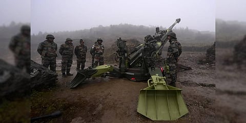 Indian Army soldiers stand next to a M777 Ultra Lightweight Howitzer positioned along the LAC in Arunachal Pradesh (File Photo | AFP)