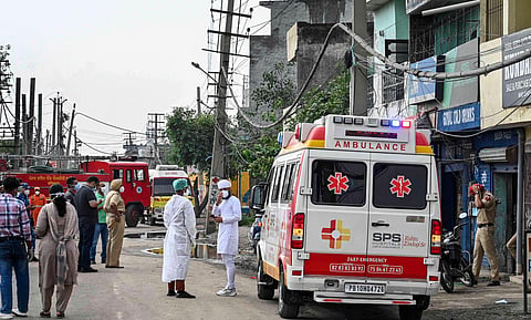 Security and other Emergency Services personnel with an ambulance at the site after a gas leak incident in the Giaspura area, in Ludhiana district, Sunday, April 30, 2023. ( Photo | PTI)