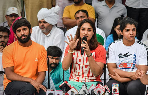 (From L to R) Wrestlers Bajrang Punia, Vinesh Phogat and Sakshi Malik speak with the media during their protest at Jantar Mantar, in New Delhi, Sunday, April 30, 2023. (Photo | PTI)