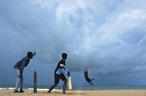 Boys play a game of cricket as dark clouds looms over Foreshore estate beach in Chennai on Tuesday evening | ASHWIN Prasath