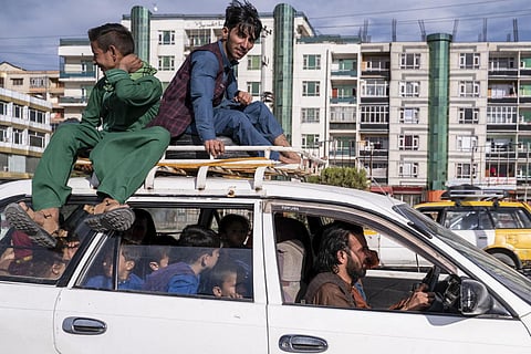 In this photograph taken on April 24, 2023, Afghan boys travel in a Toyota Corolla taxi in Kabul.(AFP)