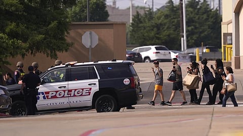 People raise their hands as they leave a shopping center following reports of a shooting, Saturday, May 6, 2023, in Allen, Texas. (Photo | AP)