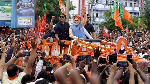 Prime Minister Narendra Modi waves at supporters during a roadshow ahead of Karnataka Assembly elections, in Bengaluru. (Photo | Shashidhar Byrappa)