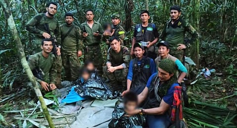 Members the Army pose with four Indigenous children who were found alive after spending more than a month lost in the Colombian Amazon jungle following the crash of a small plane. (Photo | AFP)
