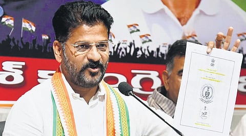 TPCC chief A Revanth Reddy shows a document as he addresses the media  at the Gandhi Bhavan in Hyderabad on wednesday