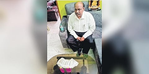  Telangana University Vice-Chancellor Dachepalli Ravinder Gupta with cash seized from him at his residence on Saturday