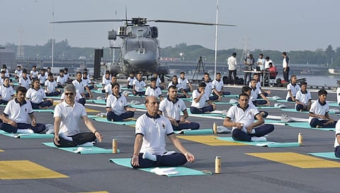 Defence Minister Rajnath Singh participates in yoga onboard aircraft carrier INS Vikrant as part of International Yoga Day in Kochi on Wednesday. Yoga was the mantra on Wednesday as millions across India breathed in and out - mindfully - and twisted and turned to celebrate the International Day of Yoga. (Photo | A Sanesh, EPS)