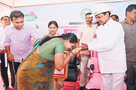 A beneficiary expresses her gratitude as Chief Minister K Chandrasekhar Rao presents her the documents for a  2BHK house in Kollur on Thursday