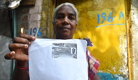 57-year-old Maari of Mattan Kuppam shows her husband’s fishing ID. (Photo | P Ravikumar, EPS)  ​