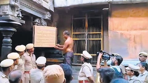 HR&CE staff removing the board placed by podhu dikshithars at the entrance of Kanagasabai  at the Nataraja temple on Monday | Express