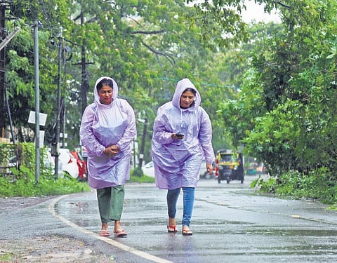 Women wearing raincoats walk on a road  in  Kadavanthra under heavy rain. (Photo | TP Sooraj)