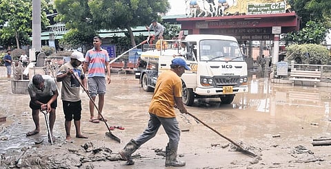 Workers clean the area at Nigambodh Ghat near ISBT after the flood water receded on Wednesday | parveen negi