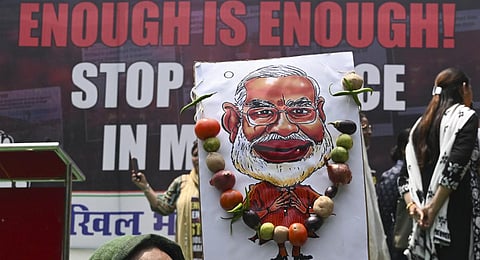 A caricature of Prime Minister Narendra Modi on the backdrop of a Congress protest in New Delhi, over sexual violence against women in the ongoing ethnic violence in Manipur. (Photo | AFP)