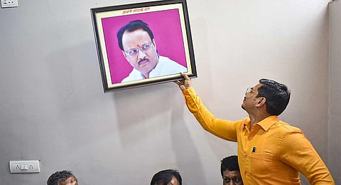 Representational image of NCP workers removing a photo of Maharashtra Deputy Chief Minister Ajit Pawar from the party office as part of a protest against his exit from the Sharad Pawar-led NCP, in Solapur, Monday, July 3, 2023. 