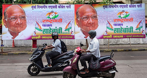 Commuters move past NCP chief Sharad Pawar's hoardings, in Mumbai, Wednesday, July 5, 2023. (Photo | PTI)