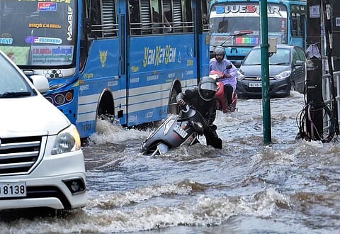 A two-wheeler rider loses his balance as he struggles to move through a waterlogged road during heavy rain in Kozhikode on Tuesday. (Photo | E Gokul, EPS)