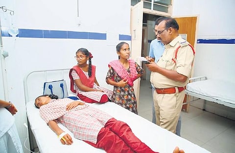 A police official conducts an inquiry after 50 students from Kasturba Gandhi Balika Vidyalaya (KGBV) in  Amarchinta fell sick after having dinner on Thursday night