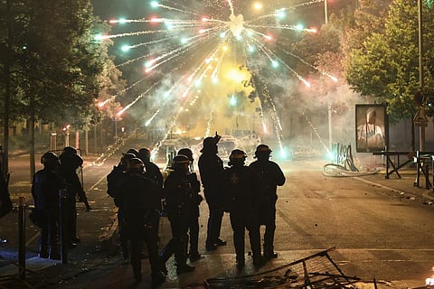 Police stand amid firecrackers on the third night of protests sparked by the fatal police shooting of a 17-year-old in Paris . (Photo | AP)