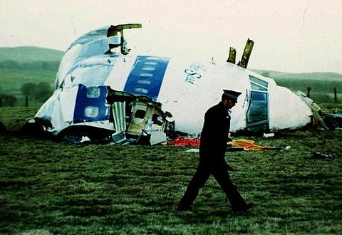 A police officer walks by the nose of Pan Am flight 103 in a field near the town of Lockerbie, Scotland where it lay after a bomb aboard exploded, killing 270 people, December 21, 1988. (AP)