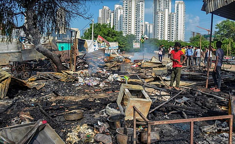 A worker inspects burnt items at a shop which was set ablaze by miscreants in a fresh case of communal violence after Monday's attack on a VHP procession in adjoining Nuh district. | PTI