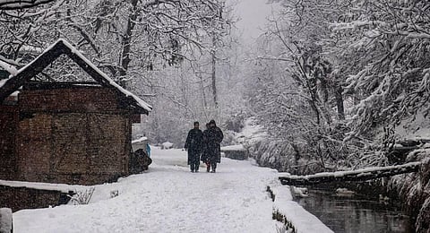 Representational Image: People walk on a snow-covered road during snowfall in North Kashmir. (File Photo | PTI)