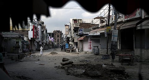 An elderly man walks in an area deserted after communal clashes in Haryana's Nuh, India, Tuesday, Aug 1, 2023. (Photo | AP)