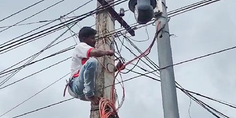 An APEPDCL lineman disconnecting the power supply to the traffic help desk in Parvathipuram-Manyam district on Friday| Express