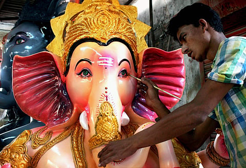 An artist gives final touches to an idol of Lord Ganesha ahead of Ganesh festival. (PTI)