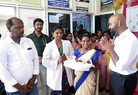 Nagapattinam Collector Johny Tom Varghese handing over the child to her parents at Nagapattinam General Hospital on Monday | Express