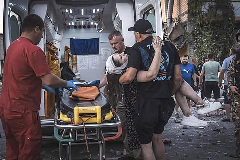 People carry a wounded person from a damaged building after Russian missile strikes in Pokrovsk, Donetsk region, Ukraine, Monday, Aug. 7, 2023. 