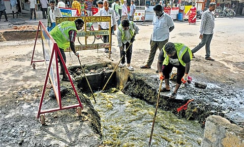 VMC sanitation workers involved in cleaning up the drain at Gunadala centre in Vijayawada on Tuesday | Prasant Madugula