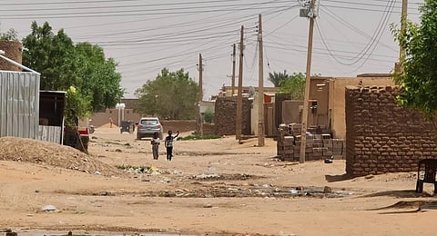 FILE: Youths walk on a street as fighting continues in Khartoum. (Photo | AFP)