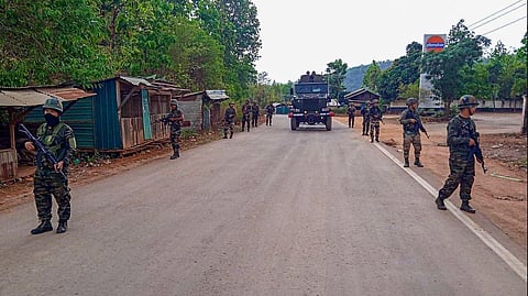 FILE - Army and Assam Rifles personnel conduct a flag march in violence-hit areas across Manipur. 