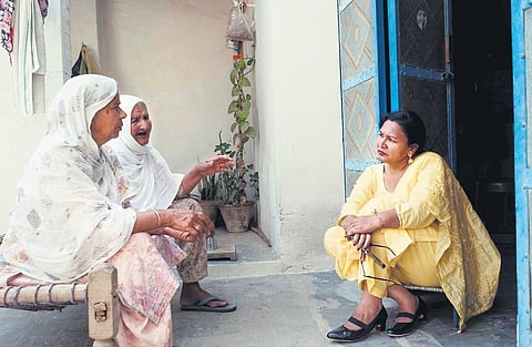 Satwinder Kaur Satti with the family of one of the abandoned brides